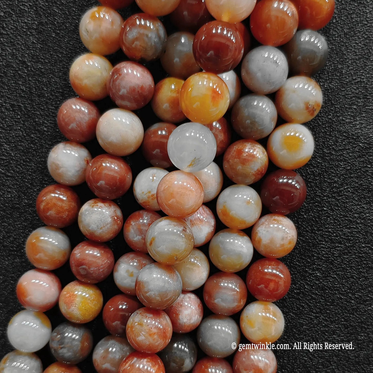 A group of coral jade crystal beads strands showing rich floral patterns and size variations