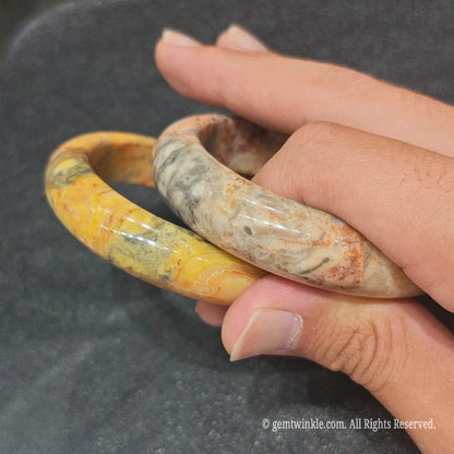 Pair of authentic carved Crazy Lace Agate bangles showing intricate multi-colored swirl patterns
