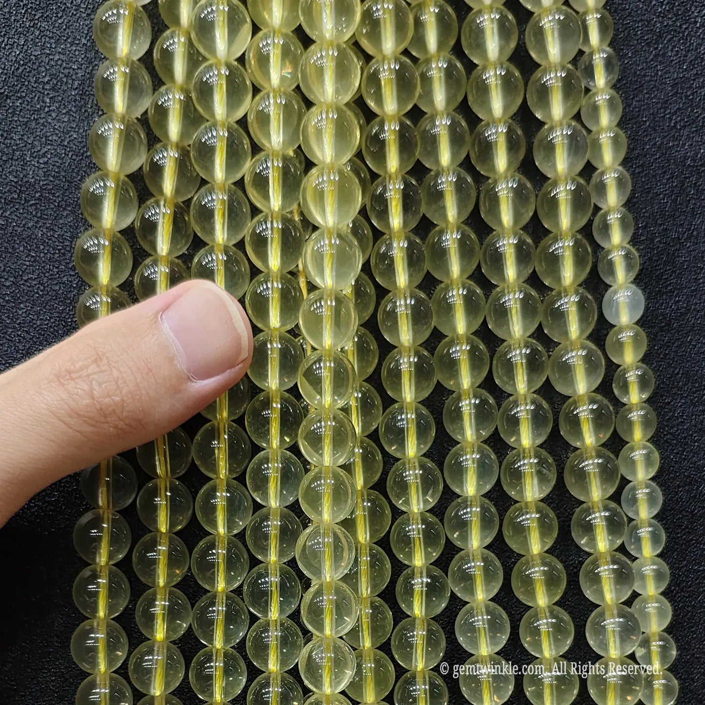 Hand held preview of B plus grade creamy lemon citrine quartz strands in 8mm 10mm sizes for custom beaded bracelets
