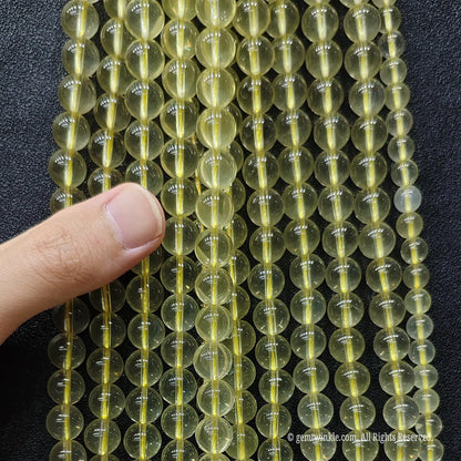 Hand held preview of B plus grade creamy lemon citrine quartz strands in 8mm 10mm sizes for custom beaded bracelets