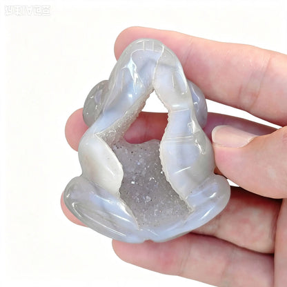 Agate crystal frog figurine showing wide hollow geode druzy opening through body held in hand