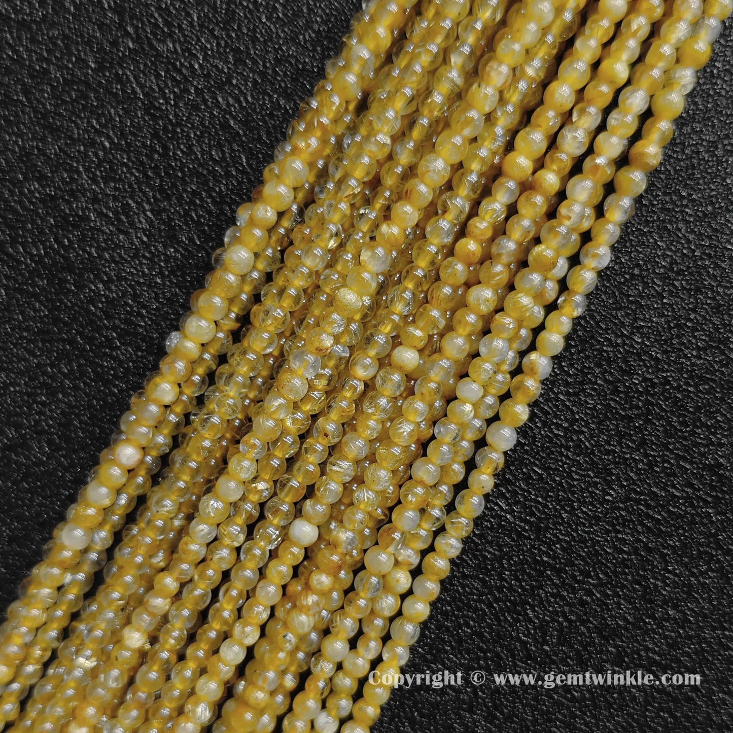 Four delicate strands of un-dyed 3mm dainty jewelry beads displaying dense B grade golden needle inclusions inside real quartz rounds from factory supplier