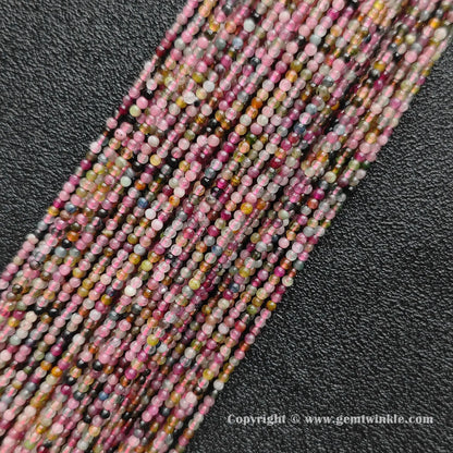 Multiple strands of dainty semi translucent multi color tourmaline 2mm mini beads on dark background