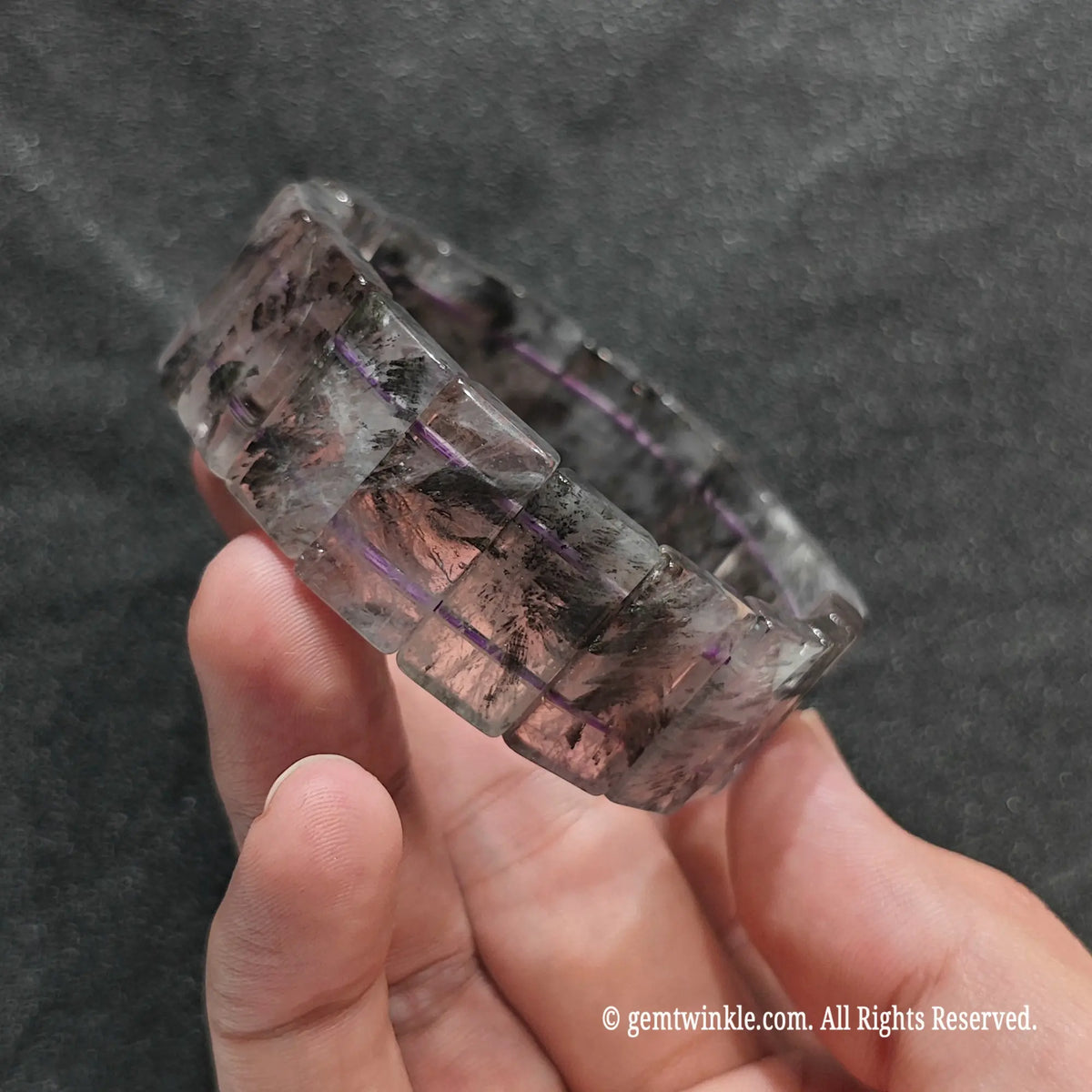 Perspective shot of a dark boho auralite 23 flat bead wristlet highlighting dark mineral zoning patterns[cite: 6]