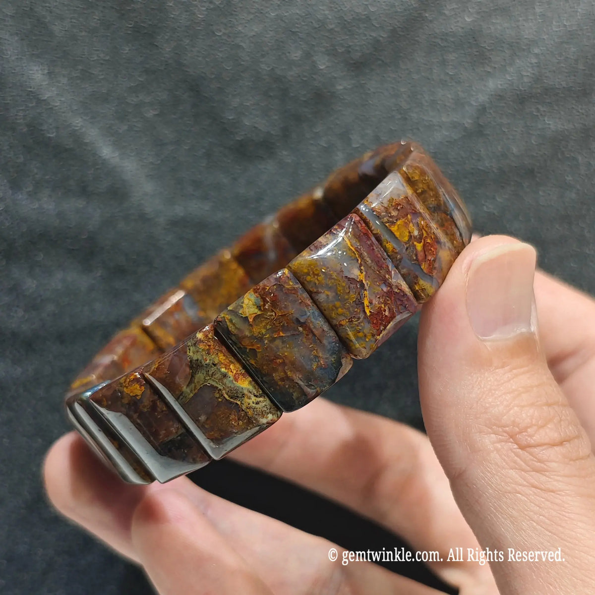 Perspective shot of a dark boho fiery pietersite flat bead cuff highlighting natural mineral texture