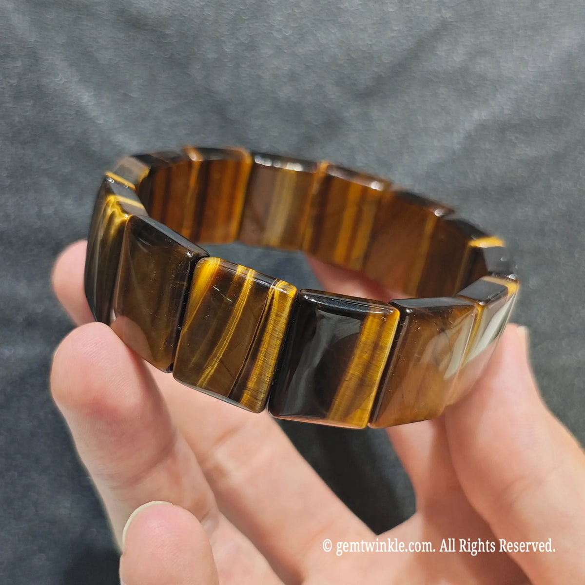 Perspective shot of a dark boho yellow tiger eye flat bead wristlet highlighting brilliant silky luster[cite: 5]