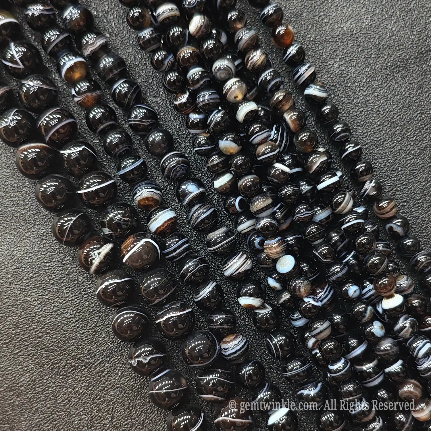Multiple strands of deep brown and black banded agate loose gemstone beads from Donghai crystal market with rich contrast bands