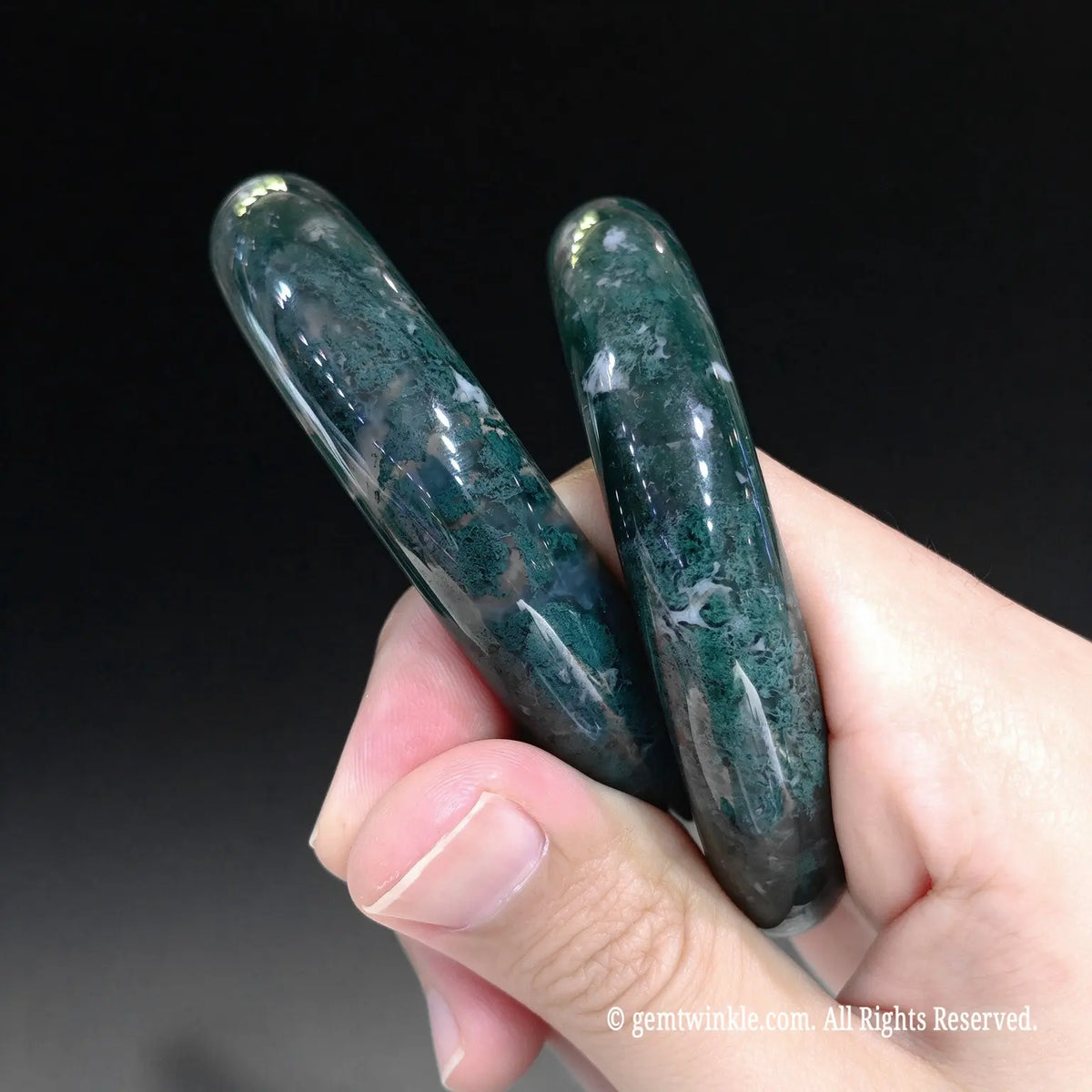 Side angle of dark green dendritic chalcedony cuff bangles showing smooth rounded contours and high gloss polish