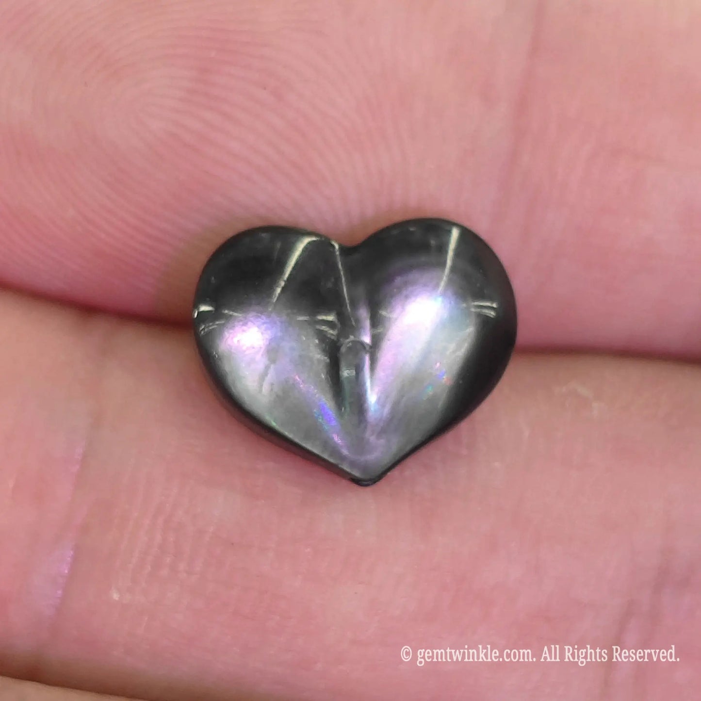 Dark mother of pearl 12mm heart bead close up view showing defined center crease and charcoal metallic luster
