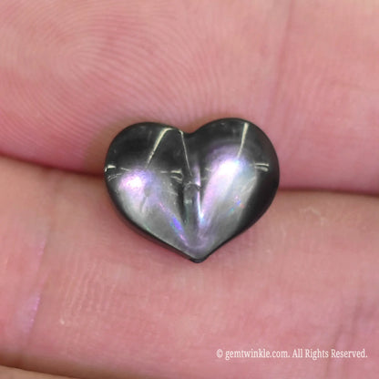 Dark mother of pearl 12mm heart bead close up view showing defined center crease and charcoal metallic luster