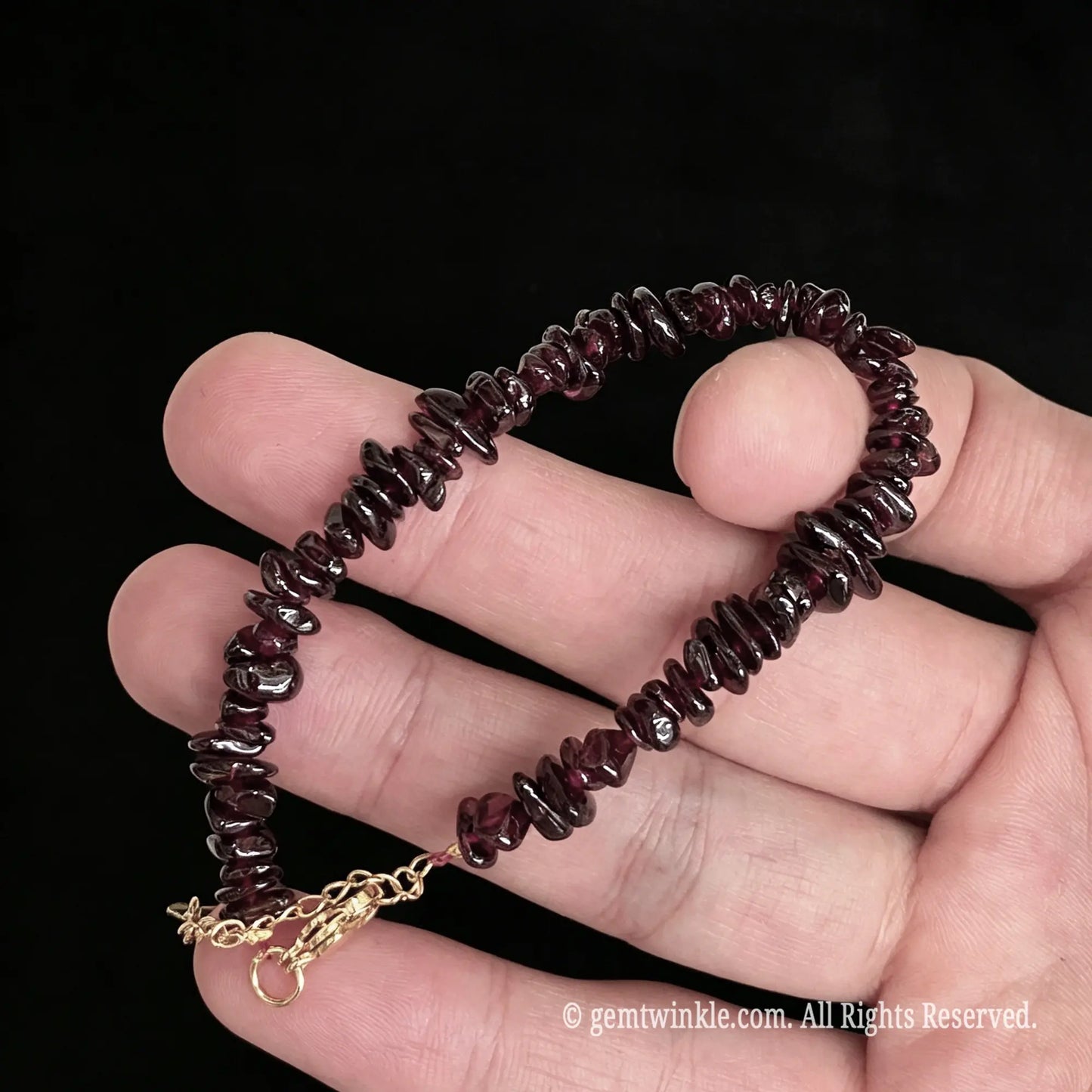 deep wine red garnet raw chip nugget bracelet held on hand showing lustrous gemstone beads