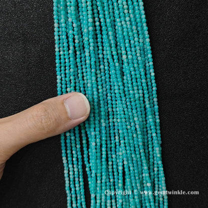 Hand holding delicate natural amazonite 3mm micro seed bead strands to demonstrate size scale and vivid luster