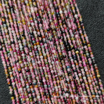 Close up detail of delicate semi translucent multi color tourmaline 2mm micro round beads