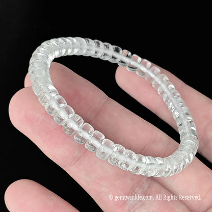 Delicate clear quartz abacus bead stackable bracelet styled on wrist displaying minimalist clear stone design