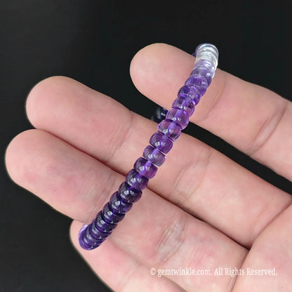 Delicate gradient amethyst disc bead stretch bracelet styled on wrist displaying slim stackable design