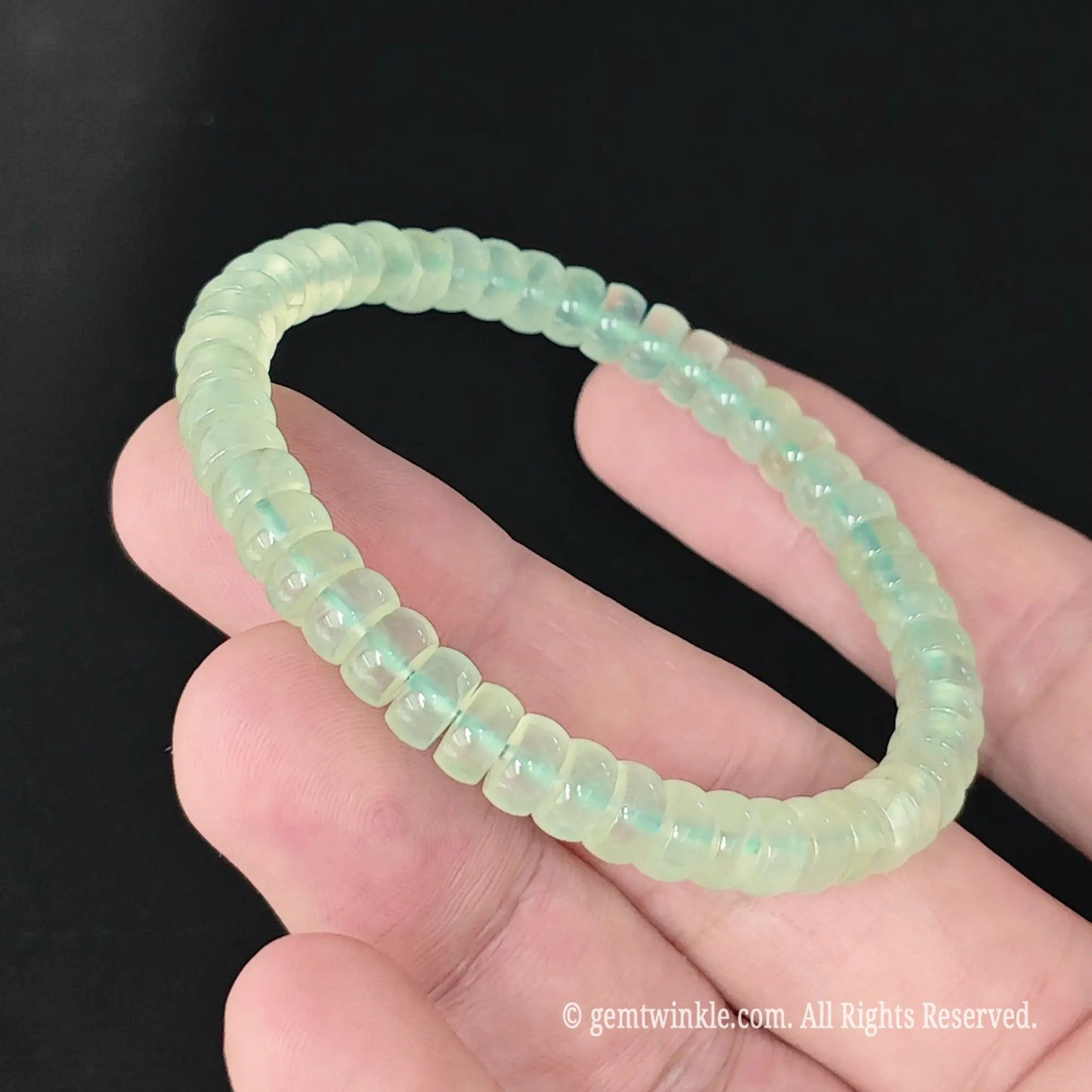 Delicate prehnite abacus bead stackable bracelet styled on wrist displaying pastel green finish