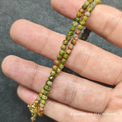 Detailed view of 3mm micro faceted unakite necklace showing multi angle facet polish and natural stone tones