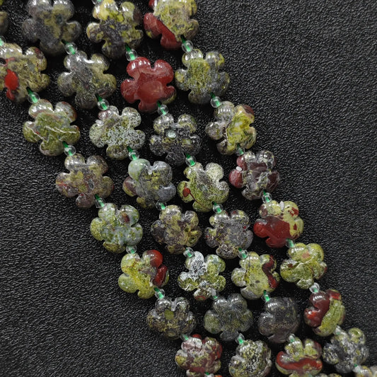 Macro closeup of dragon blood jasper plum blossom carved beads 15mm showing green and red mottled texture