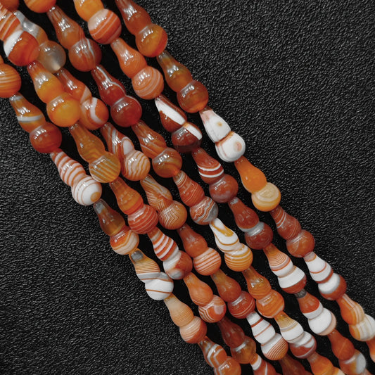 Macro closeup of color-dyed banded agate gourd beads showing distinct silk stripe patterns