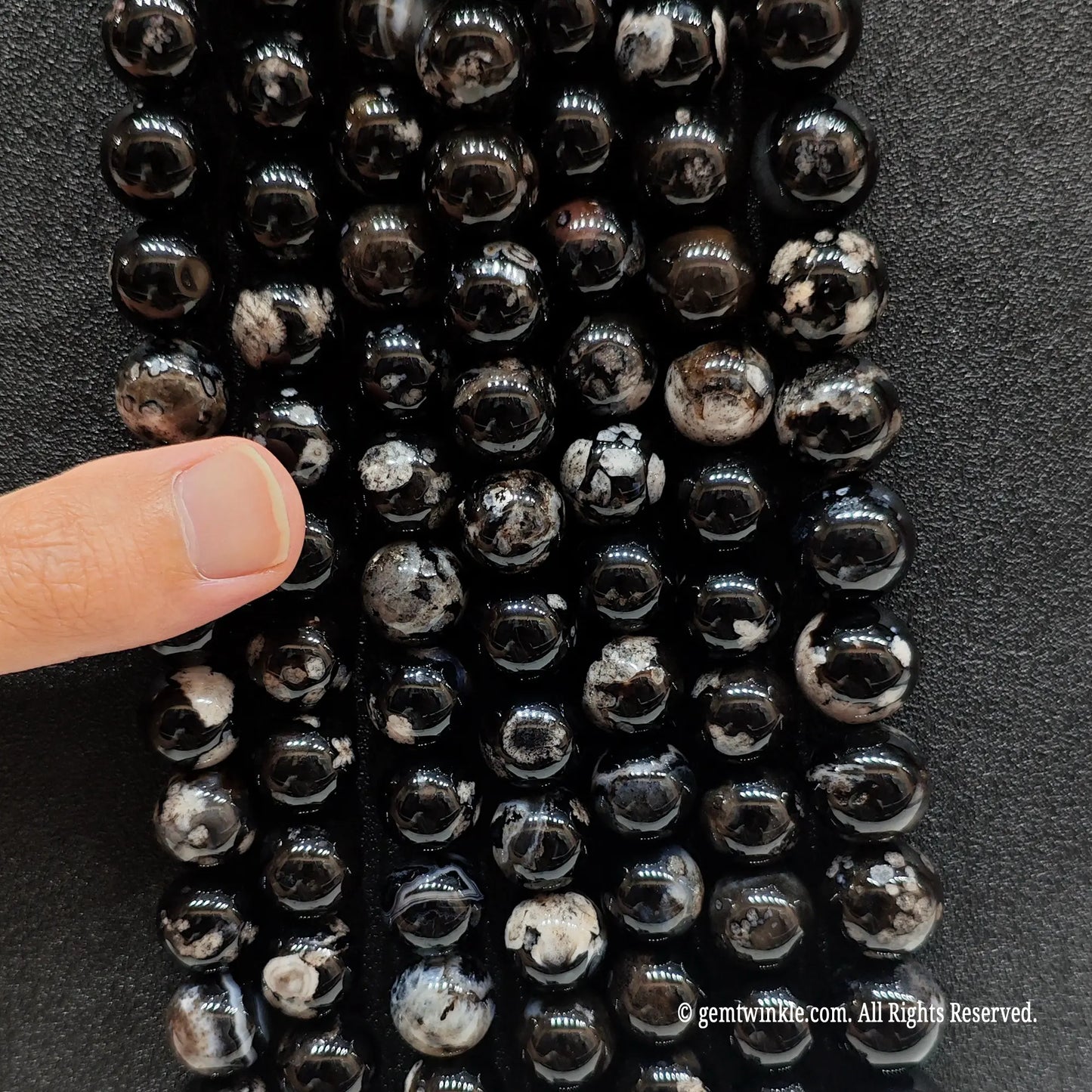 Inspecting a batch of dyed black chalcedony crystal beads from 6mm to 16mm with natural agate base for store size chart validation