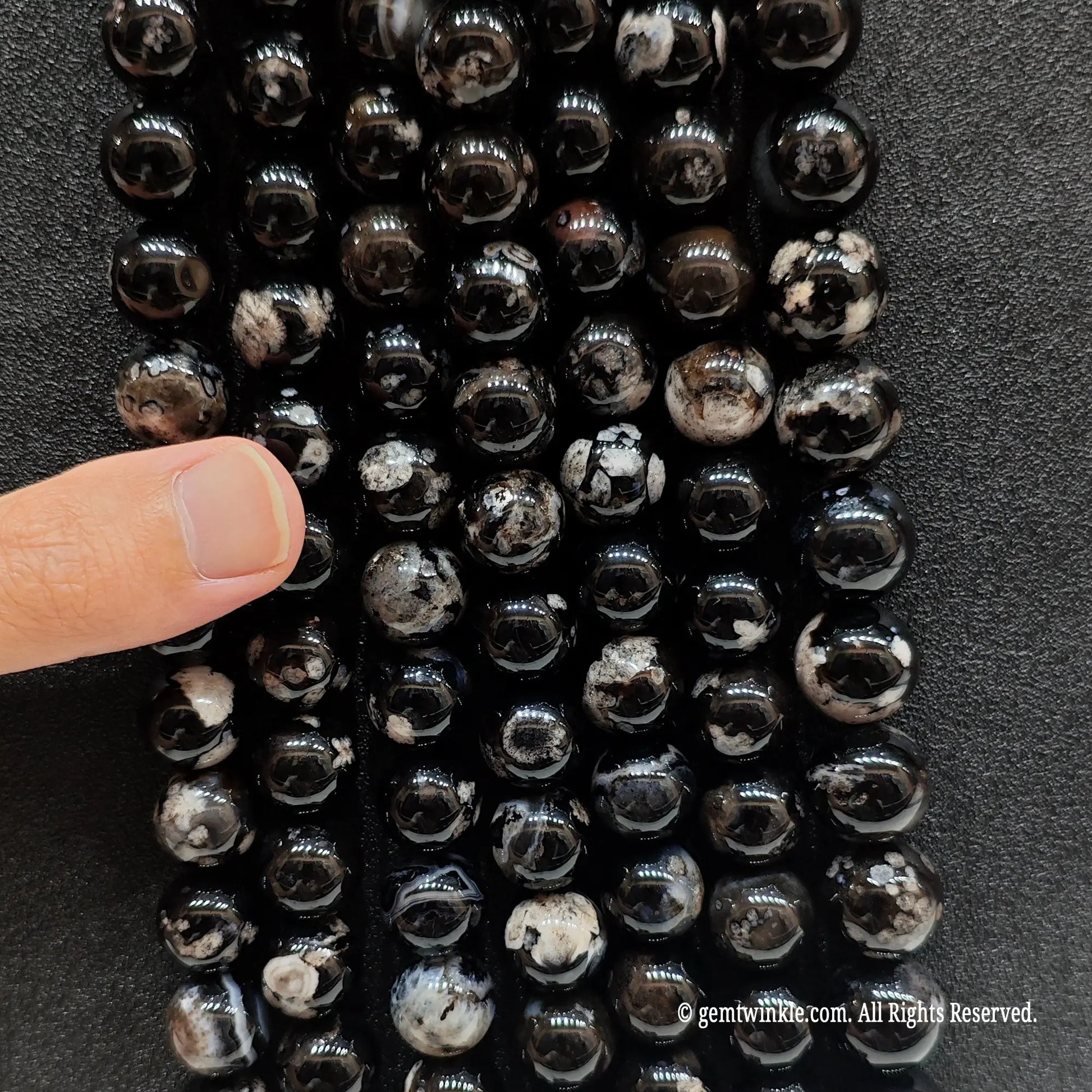 Inspecting a batch of dyed black chalcedony crystal beads from 6mm to 16mm with natural agate base for store size chart validation