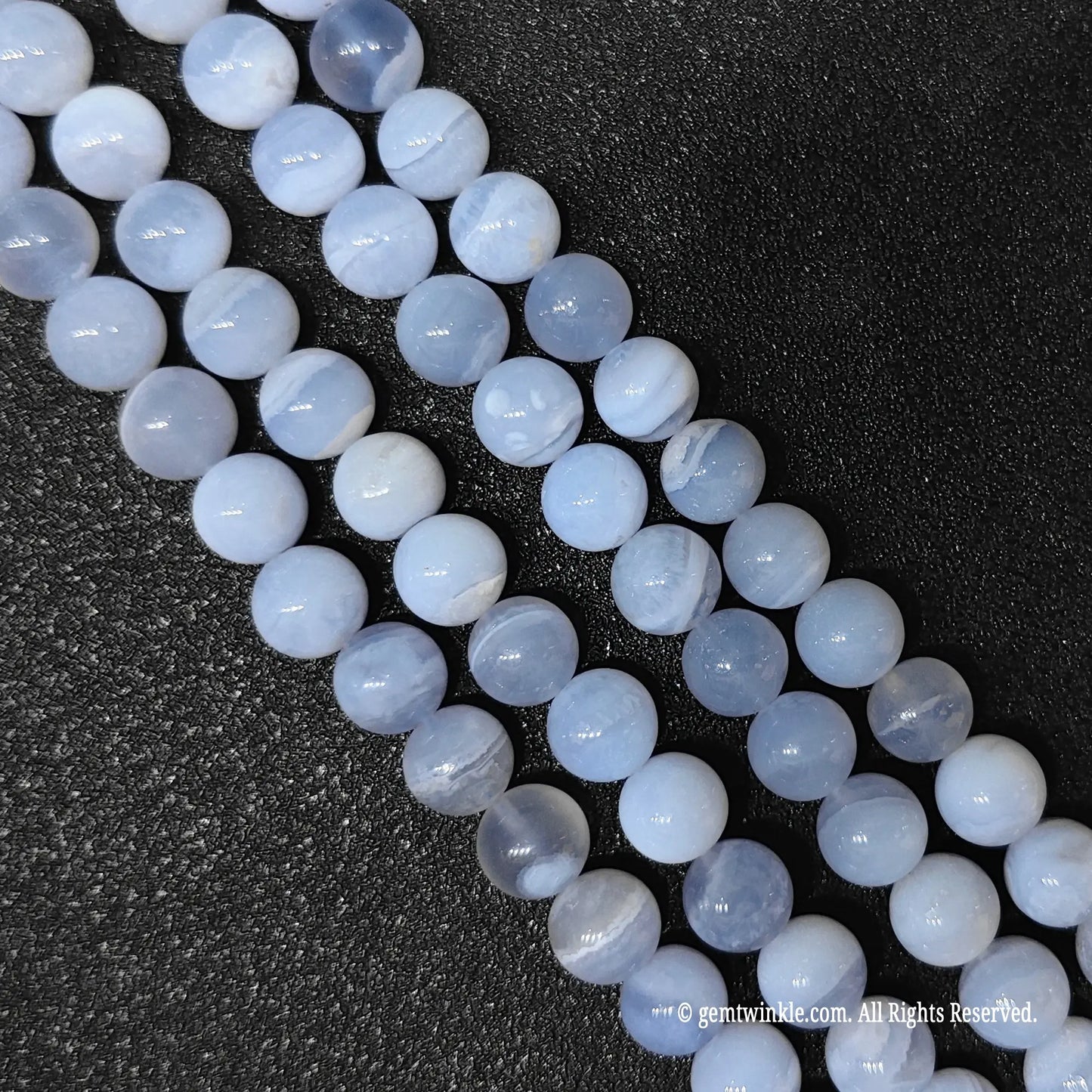 Inspecting a batch of dyed blue chalcedony crystal beads from 10mm to 12mm with natural agate base for store size chart validation