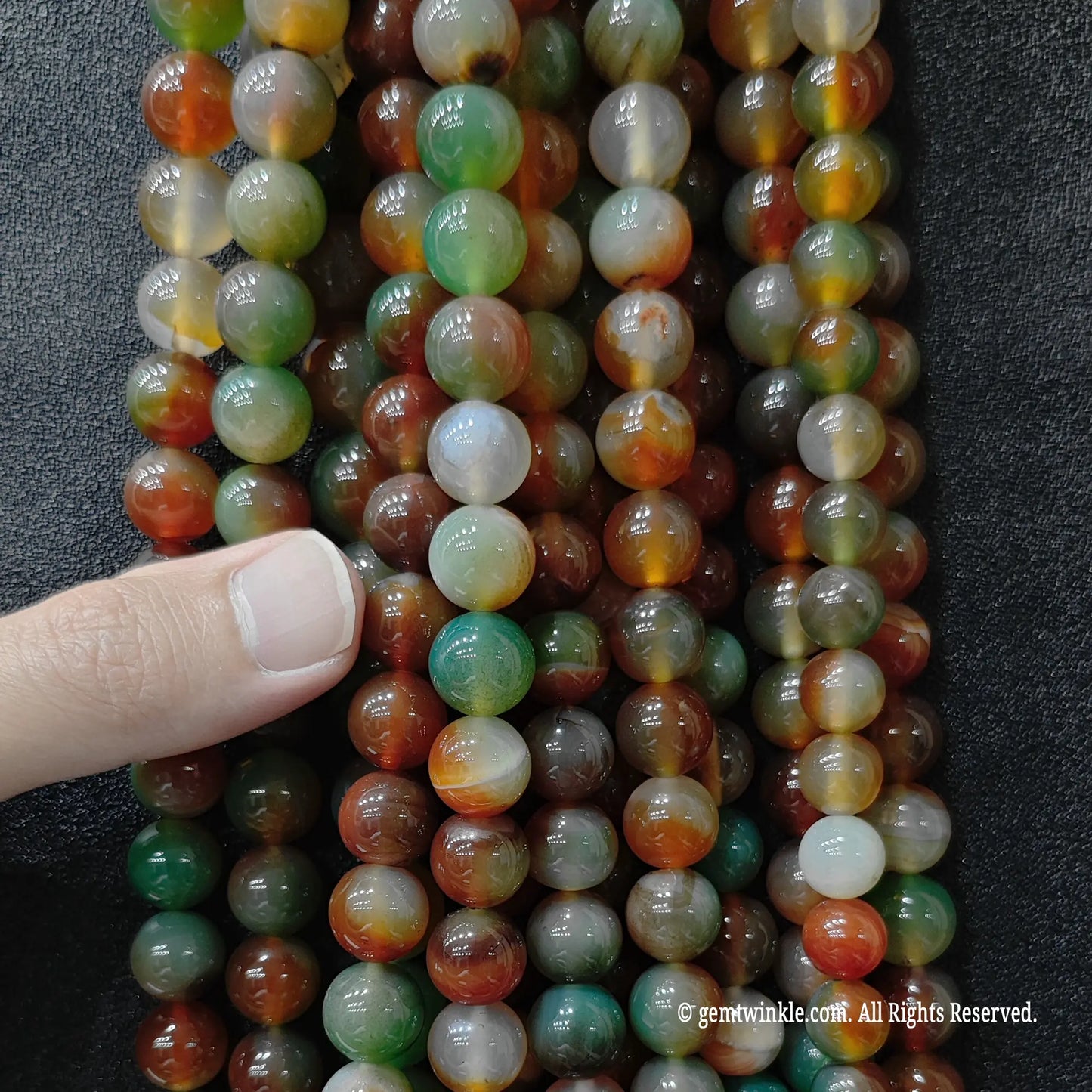 Close up of vibrant dyed Peacock Agate beads showing swirls and earthy patterns