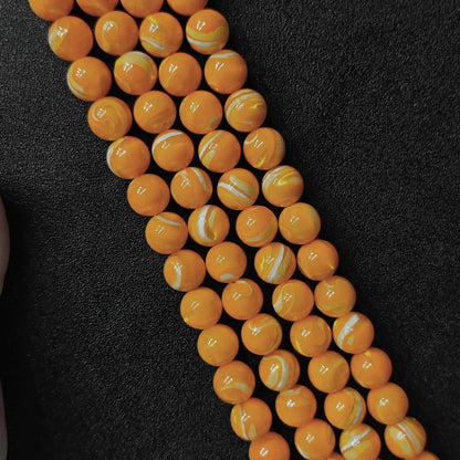Dyed yellow mother of pearl shell round beads with white banded striations macro shot