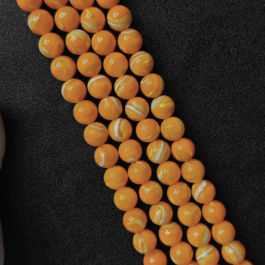 Dyed yellow mother of pearl shell round beads with white banded striations macro shot