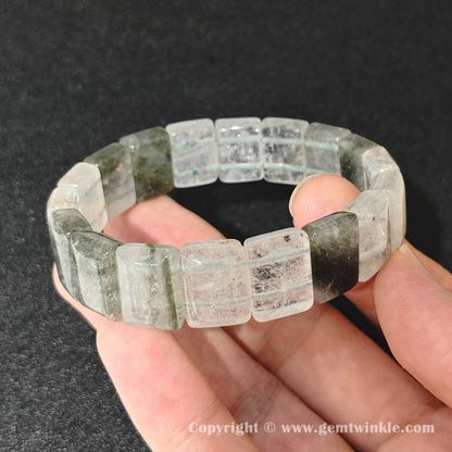 natural lodolite garden quartz bangle plate bracelet displayed over palm highlighting cloudy quartz structure