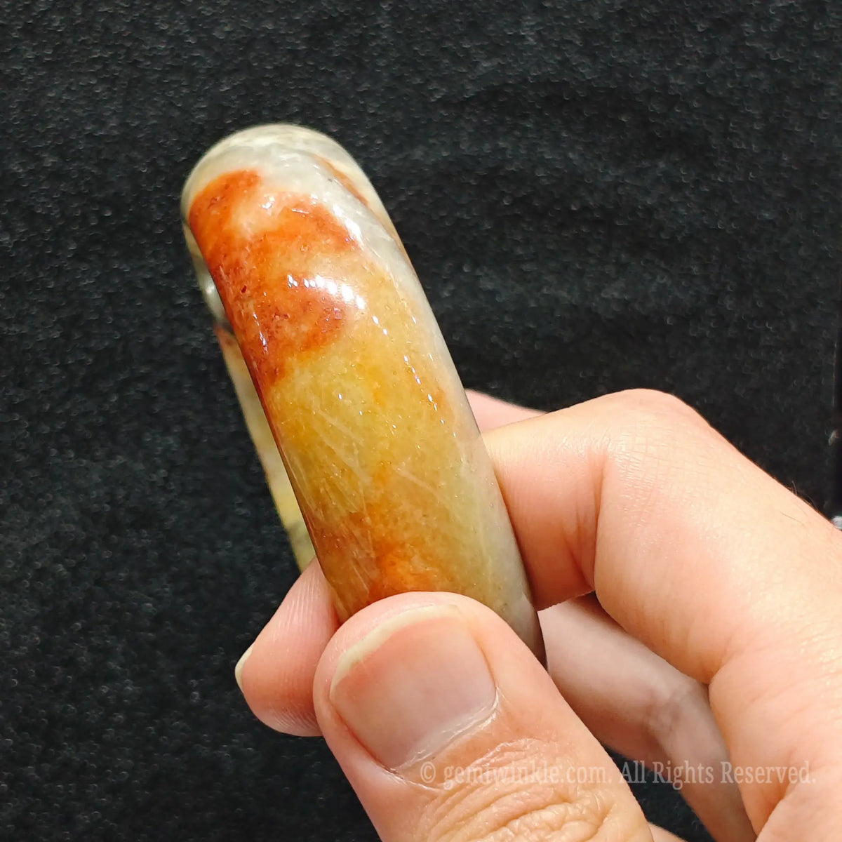 fingers holding exact piece natural red speckled crazy lace agate bangle