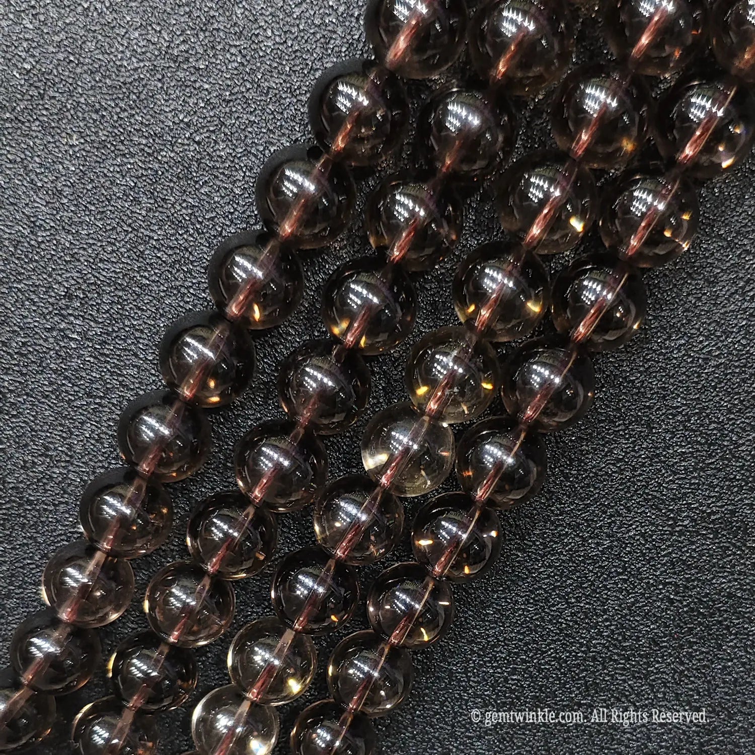 Close up of eyeclean smoky brown crystal gemstone beads showing superior diamond polish and no ice cracks