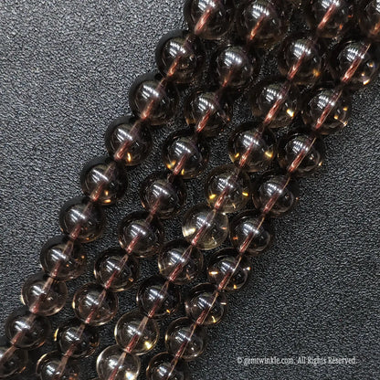 Close up of eyeclean smoky brown crystal gemstone beads showing superior diamond polish and no ice cracks