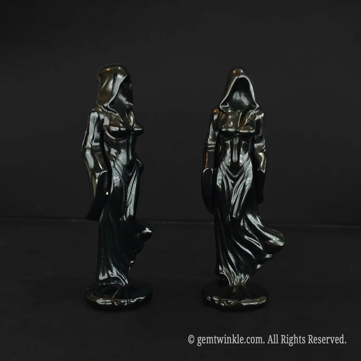 Front and back views of the faceless cloaked witch statue carved from glossy black obsidian showcasing the draped hood