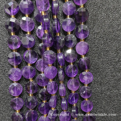 Vertical alignment of faceted amethyst coin beads on black background
