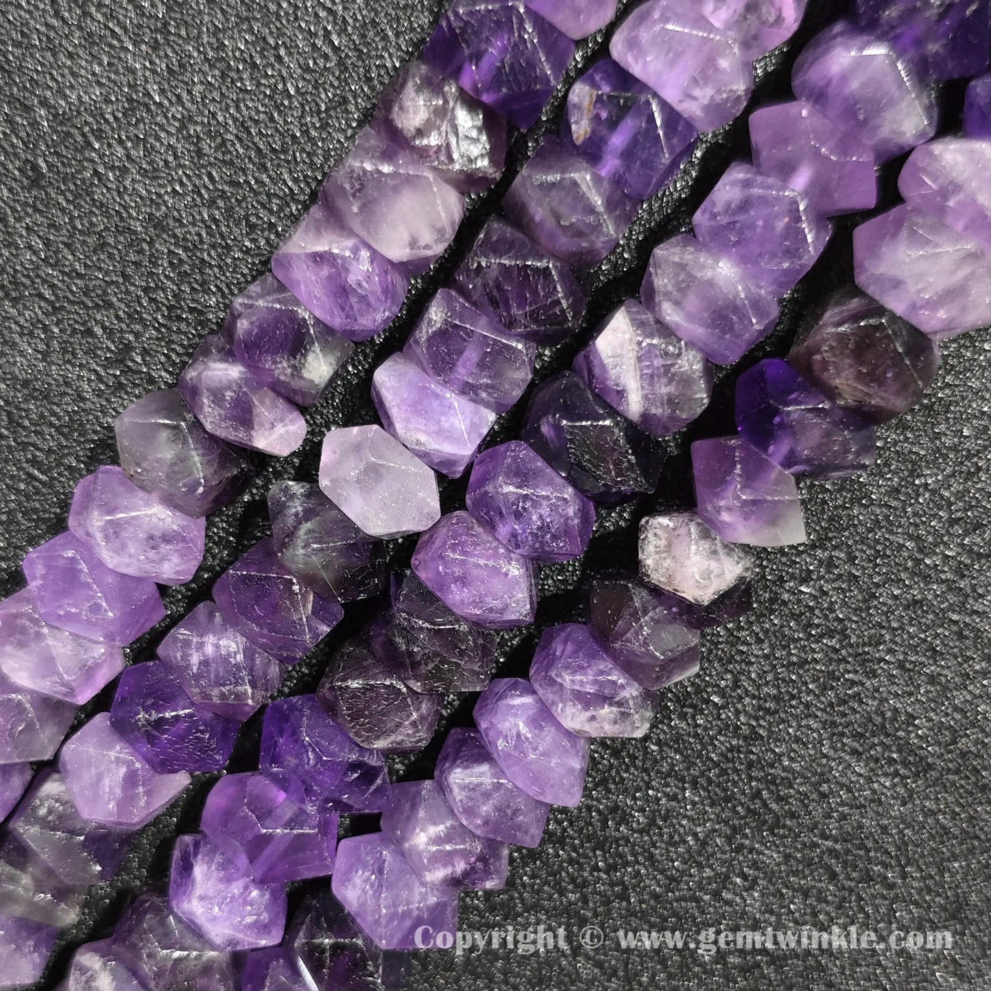 Close up view of faceted amethyst tube cylinder beads showing rich purple color