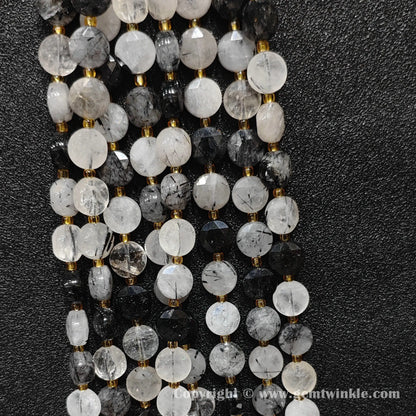 Vertical alignment of faceted black rutilated quartz coin beads on dark background
