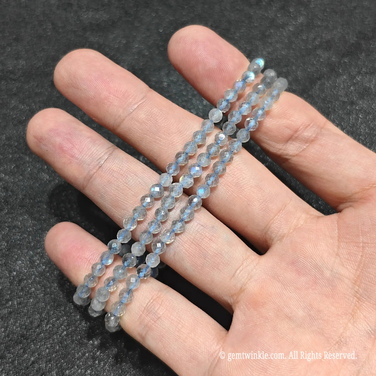Pair of natural grey moonstone faceted round bead stretch bracelets held on hand for boutique wholesale