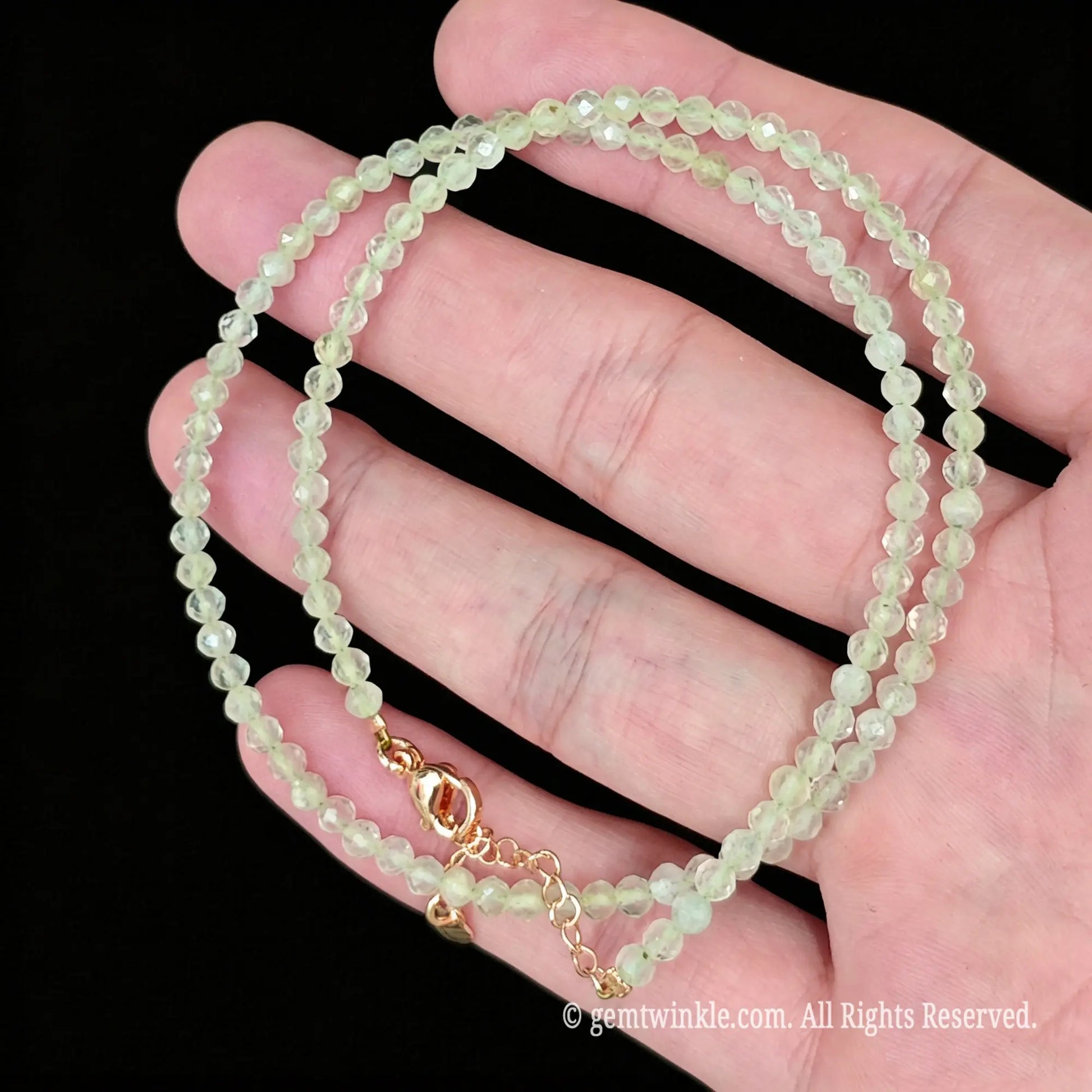 angled view of 3-4mm micro faceted prehnite beads displaying natural mineral inclusions