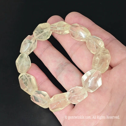 faceted yellow quartz freeform bead stretch bracelet displayed in open hand