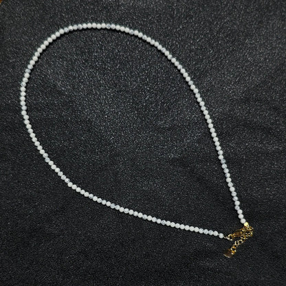 Natural faceted white howlite turquoise necklace with 3mm beads and gold extender chain layout