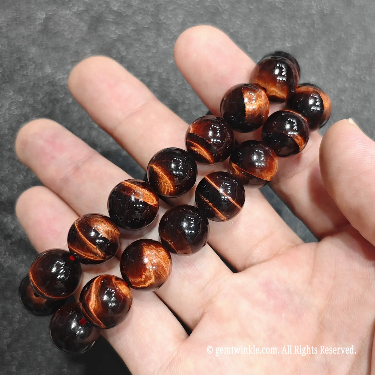 Close up view of red tiger eye gemstone beads highlighting fiery mahogany shades and optical depth