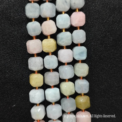 Artisan fingers holding morganite stone strands to demonstrate bead scale and translucent texture