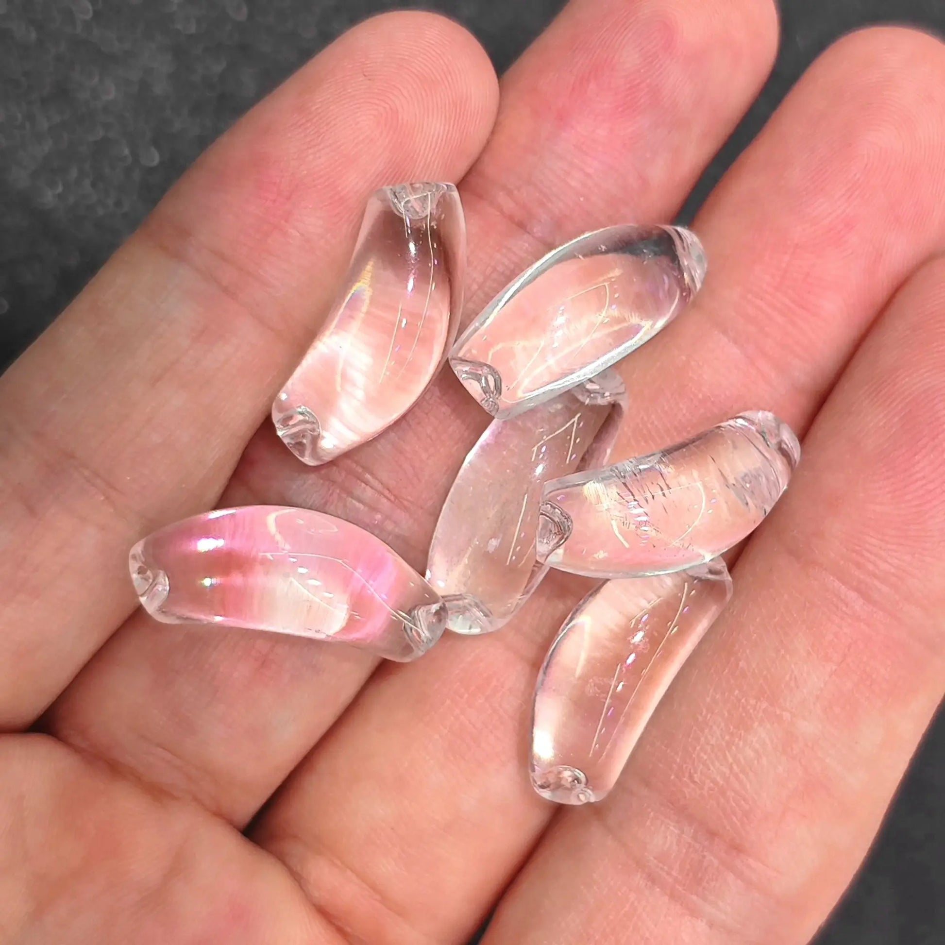 rock crystal curved tube beads showing icy water clarity placed on hand
