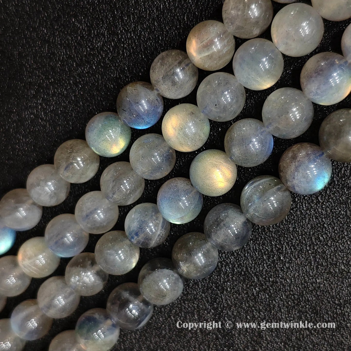 Parallel alignment of natural grey moonstone round strands highlighting glossy surface polish and mineral character