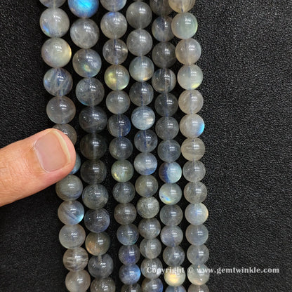 Parallel alignment of natural grey moonstone round strands highlighting glossy surface polish and mineral character