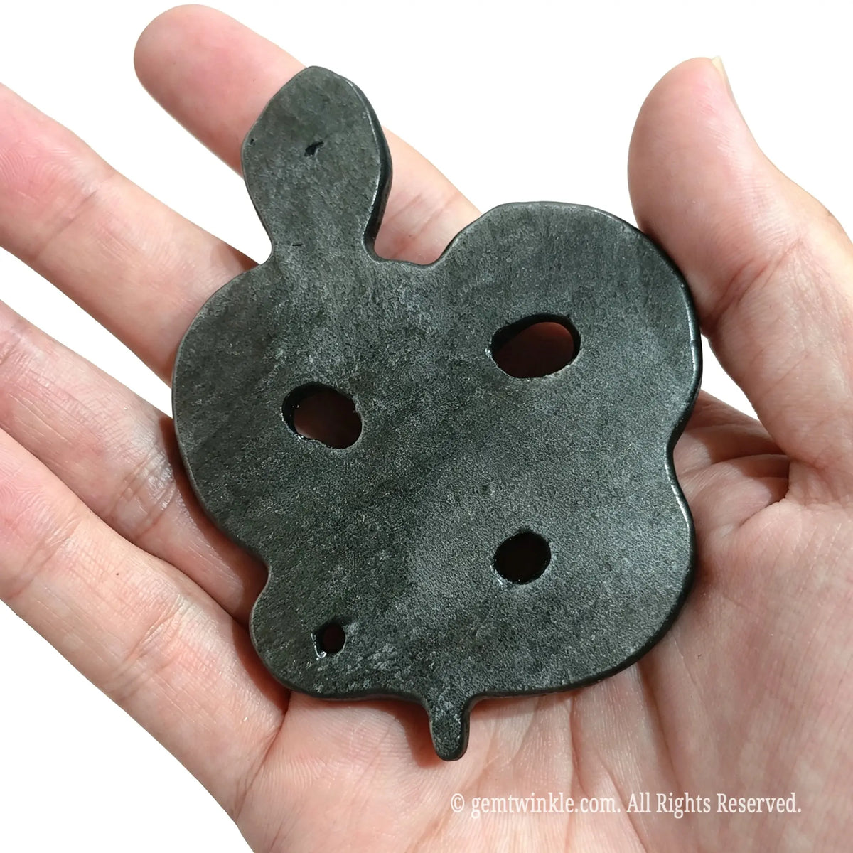 Hand holding silver sheen obsidian snake carving from behind showing smooth flat base and hollowed design