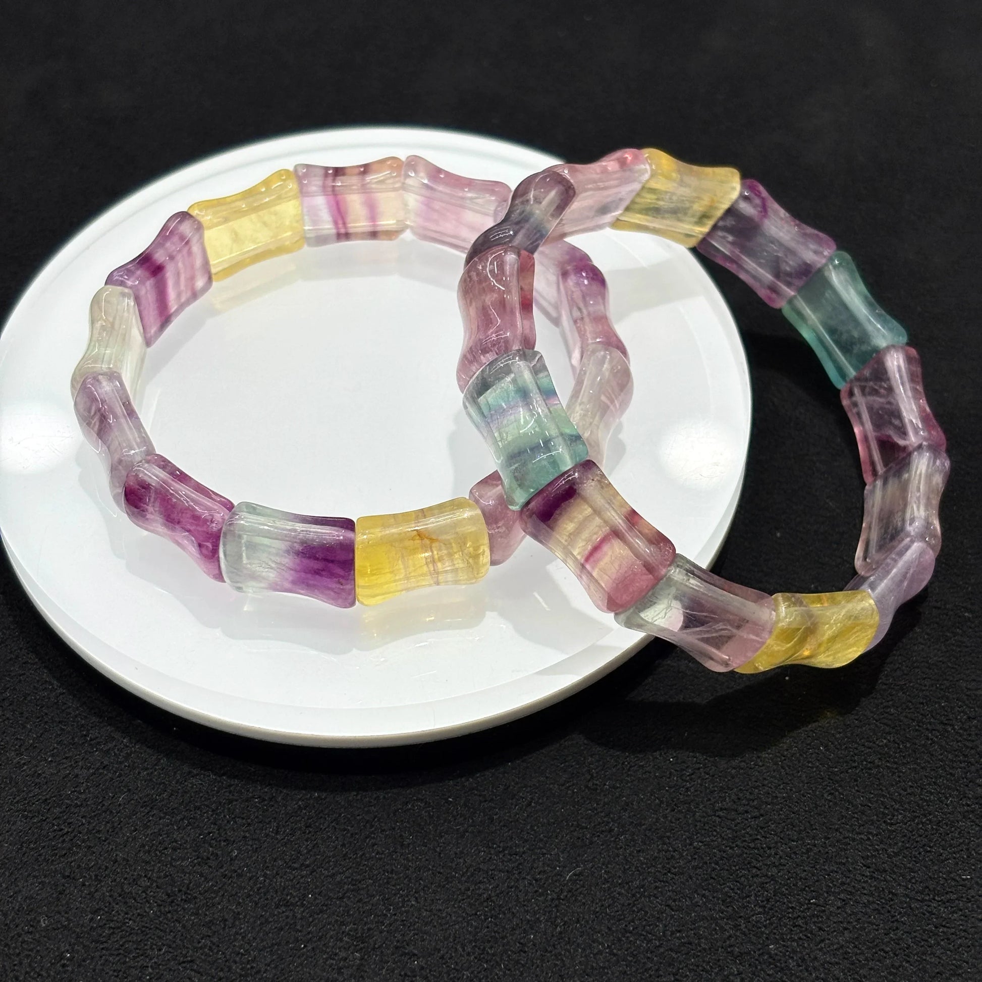 Natural Colorful Fluorite Bamboo Bead Bangle Bracelet stacked with another bracelet on white plate, black background, ideal for layering and stacking