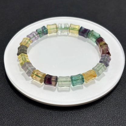 A single natural fluorite bamboo bangle laid out on a white plate, ideal for men or women as a spiritual healing accessory gift.