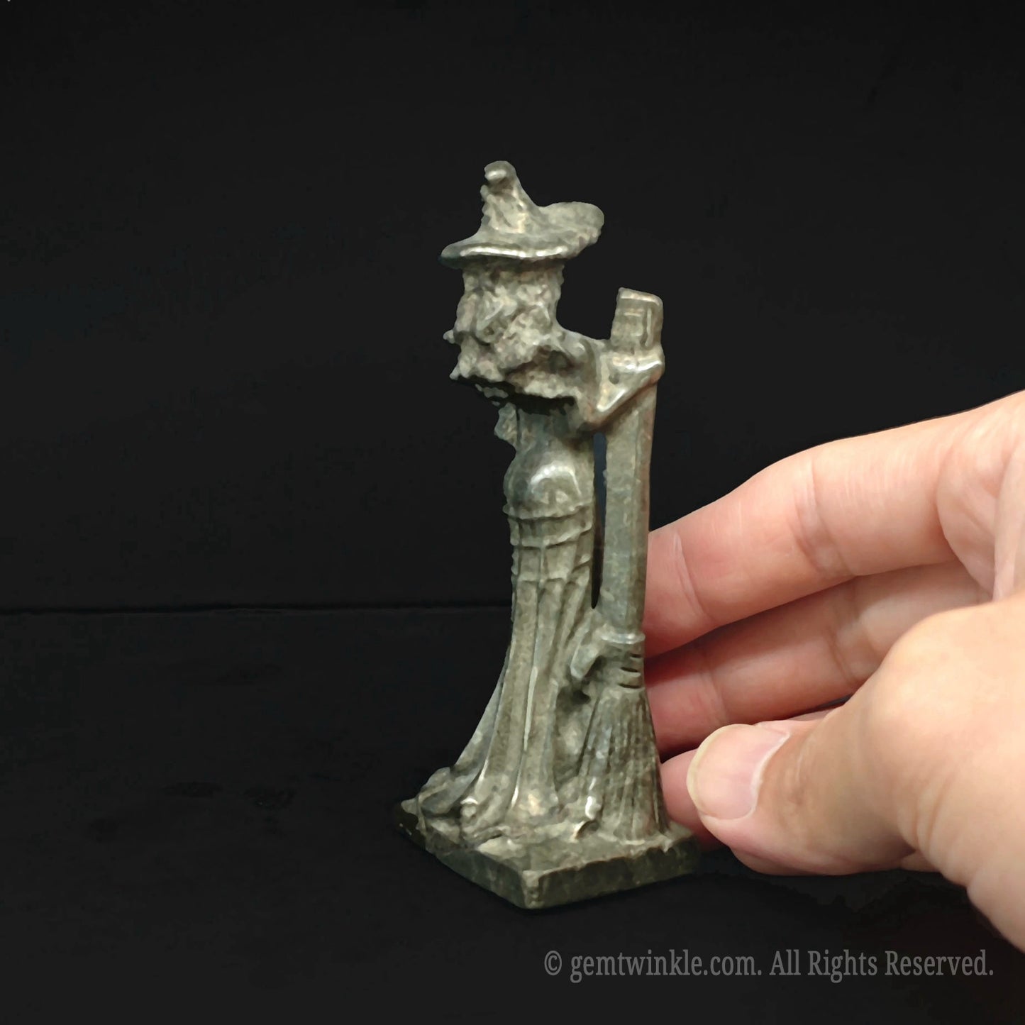 Side angle of the pyrite witch sorceress crystal carving held in hand showcasing thickness and crystalline texture